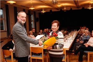 50 Jahre Spenden für die Caritas gesammelt_Gisela Meier_Schongau Schongaus katholischer Pfarrer Norbert Marxer überreicht Gisela Meier die Urkunde und das Ehrenzeichen in Gold der Caritas für 50 Jahre Mitsorge und Mitarbeit für die Caritas. Die anderen Sammlerinnen und Sammler, die die Pfarreiengemeinschaft als Zeichen des Dankes zum Kaffee eingeladen hatte, freuten sich mit Meier.
