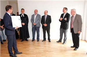 Wohnbauprojekt Dillingen_3 OB Frank Kuns übergibt noch leeren Bilderrahmen.