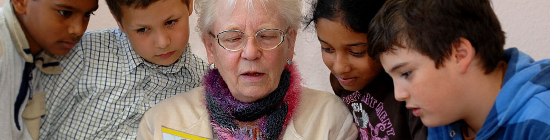 Ältere Frau liest Kindern vor