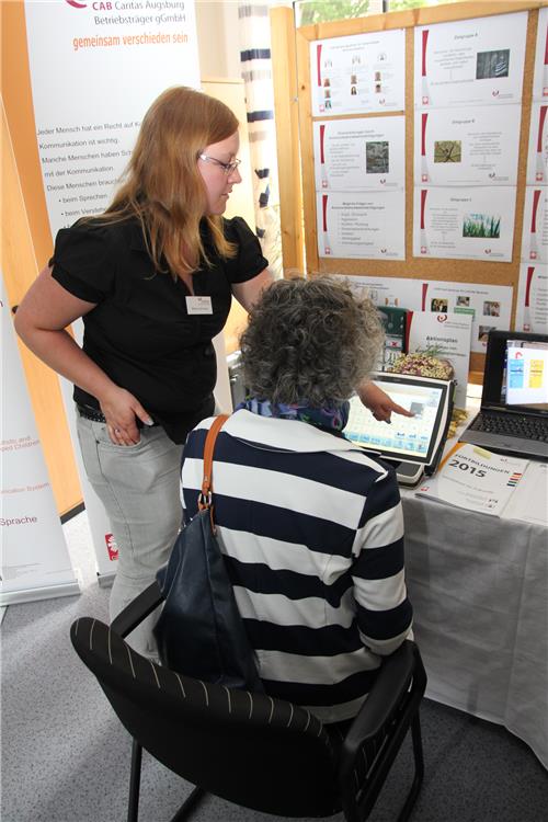 Rebecca Bullinger von der Beratungsstelle Unterstützte Kommunikation – Außenstelle Günzburg der CAB Caritas Augsburg Betriebsträger gGmbH erklärt einer Dame, wie die Augensteuerung beim dem Tobii-Sprachausgabe-Computer funktioniert.