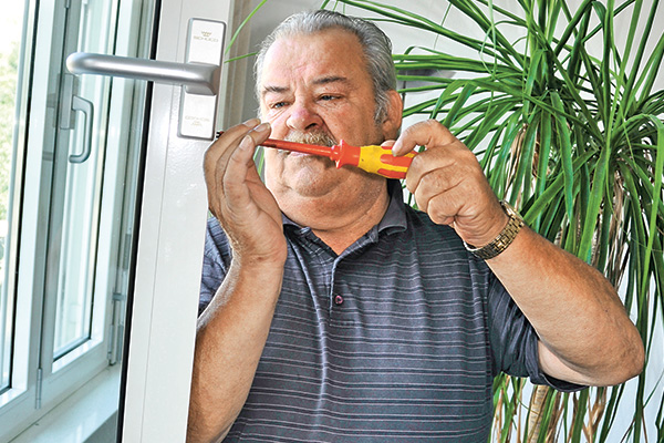 Älterer Mann repariert ein Fenster